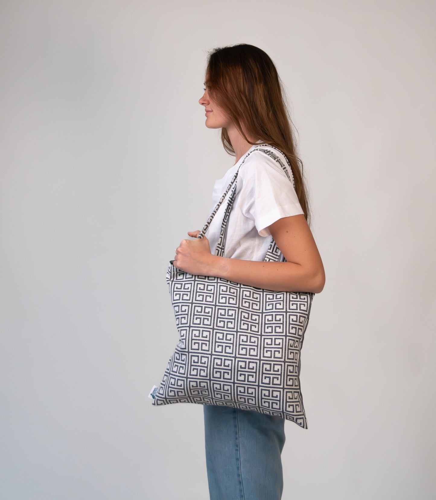 Woman holding Terrace Black Tote comfortably under arm, highlighting structured shape and pattern.
