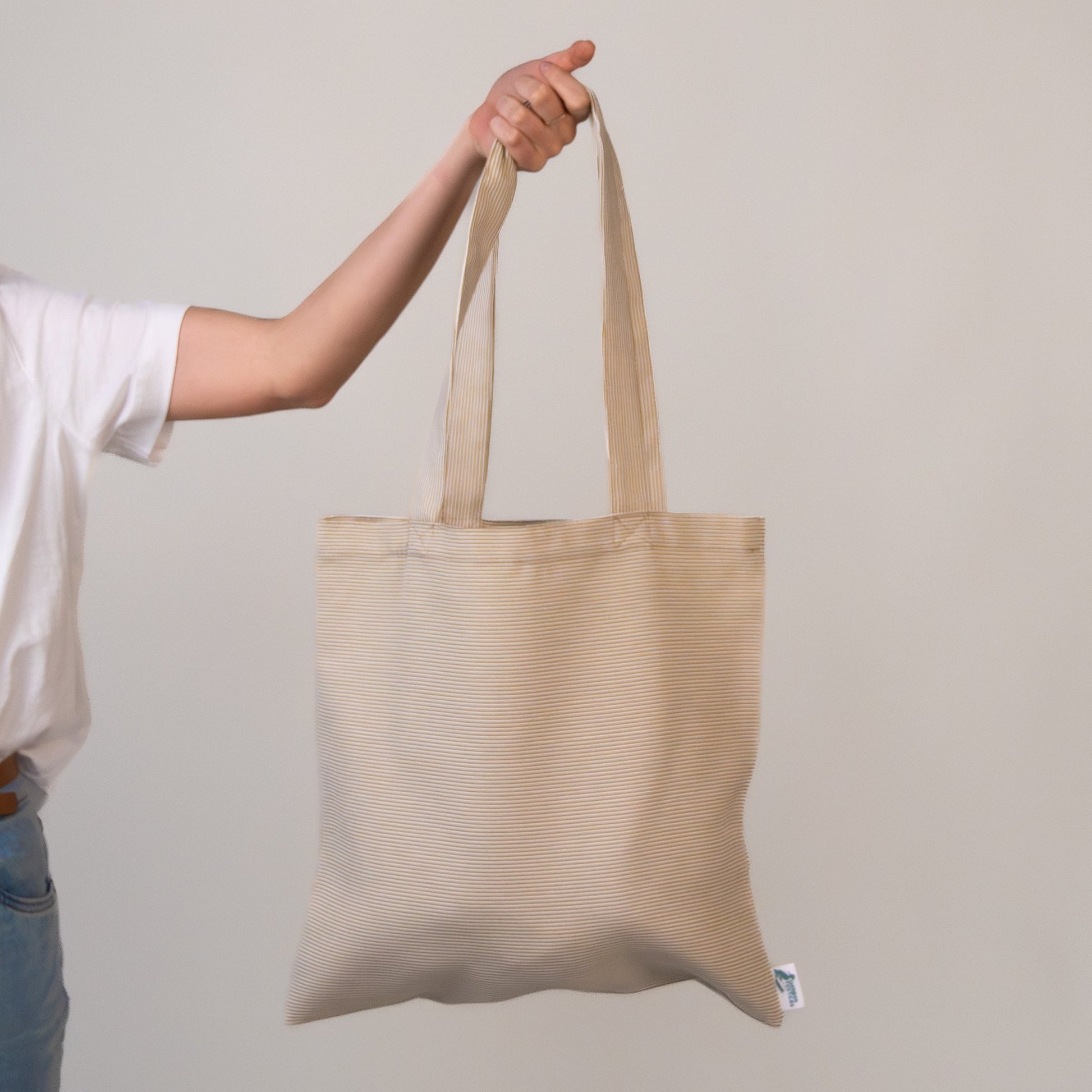 Agora Beige Tote Bag made from outdoor upholstery fabric, held against a neutral background – water-resistant, UV-protected, and ideal for beach or everyday use.