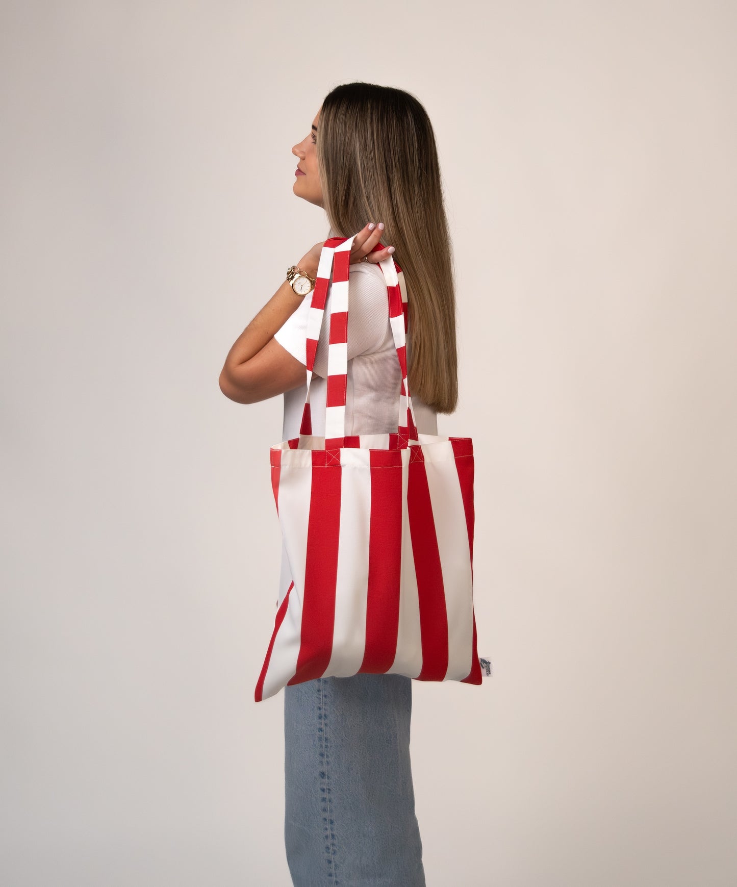 Same woman turning slightly with tote bag to the back.