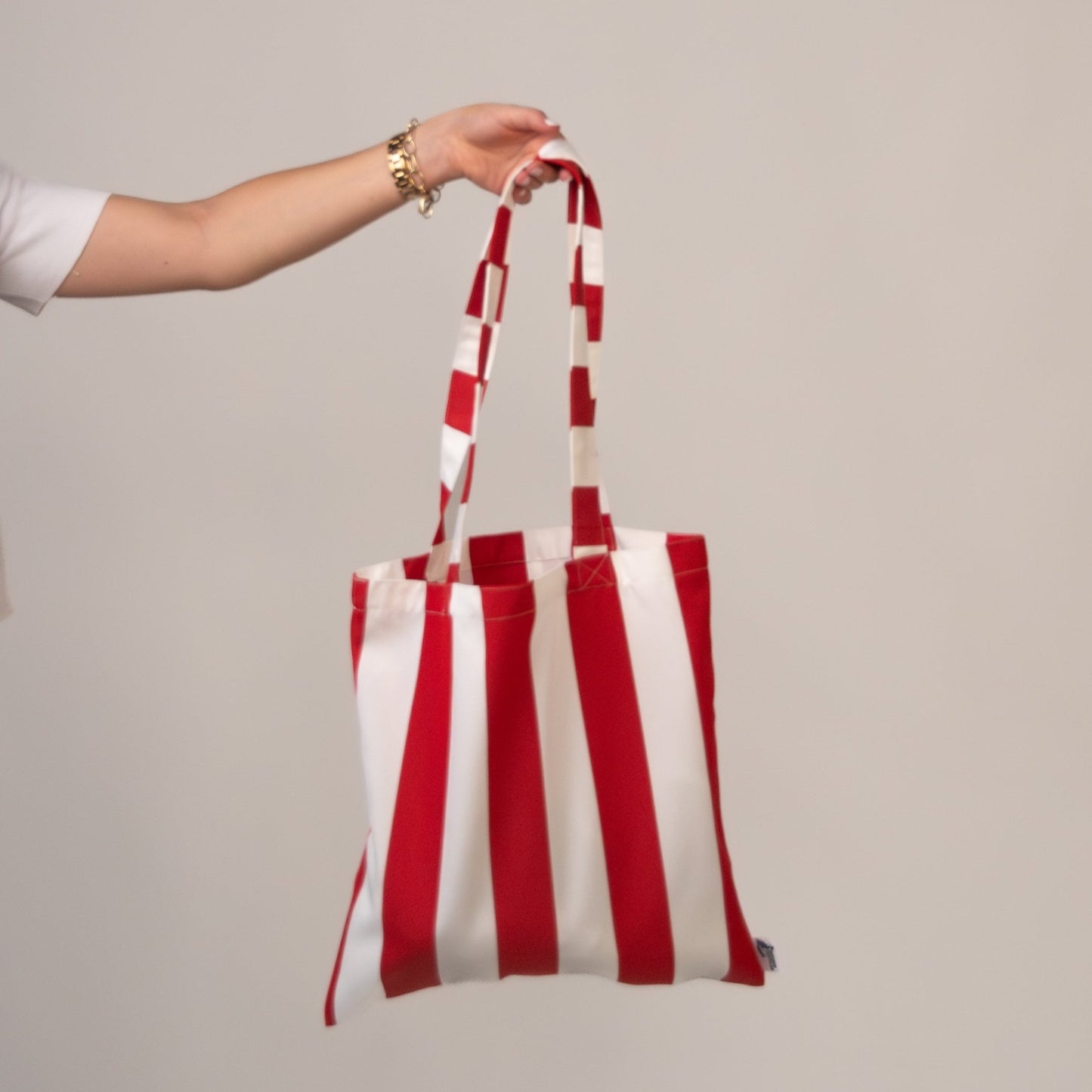 Red-and-white striped tote held by a model’s arm.